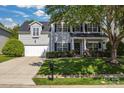 Traditional two-story house with a well-kept lawn, complemented by black shutters and a tree providing shade at 11222 Huntington Meadow Ln, Charlotte, NC 28273