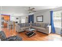 Open-concept living room with hardwood floors, a ceiling fan, and view into the kitchen at 11415 Serenity Way, Charlotte, NC 28269