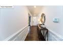Elegant hallway features hardwood floors, detailed molding, and a decorative console table with a mirror above at 118 Fordingbridge Ln, Mooresville, NC 28115