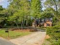 Charming brick home with mature trees and a circular driveway at 119 Lakenheath Ln, Matthews, NC 28105