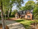 Attractive brick home featuring a lush lawn and mature trees at 119 Lakenheath Ln, Matthews, NC 28105