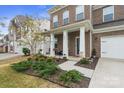 Inviting front porch with white columns, a cozy seating area, and lush landscaping at 121 Little Kennerly Dr, Mooresville, NC 28115