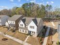 An aerial view of a two story house with white accents, manicured lawn, and tree lined street in a quiet neighborhood at 12110 Anne Blount Aly, Huntersville, NC 28078
