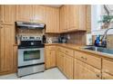 The kitchen features stainless steel appliances, wooden cabinets, and stylish tiled backsplash at 143 W College St, Stanley, NC 28164