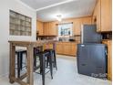 Cozy kitchen featuring bright wood cabinets, white floors, an eat in area, and modern appliances at 143 W College St, Stanley, NC 28164