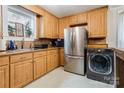 Well-lit kitchen with stainless steel appliances and wood cabinets, including washer dryer hookups at 143 W College St, Stanley, NC 28164