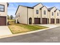 A townhouse with attached garages, neutral stucco, dark trim, and a small grass yard at 154 Shields Dr, Lincolnton, NC 28092