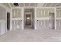 Spacious living room with unfinished walls, bare floors, and natural light streaming through the door at 2508 Rock Dam Rd, Lincolnton, NC 28092