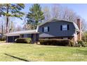 Two-story house featuring grey siding, brick, dark shutters, trimmed hedges, and a green lawn at 2650 31St Street Ne Ct, Hickory, NC 28601