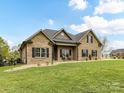 Sprawling front yard leads to a classic brick home, complete with covered entry and decorative flower pots at 3012 Ocean Dr, Monroe, NC 28110