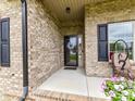 Inviting front porch with brick columns and charming floral wreath on the black front door at 3012 Ocean Dr, Monroe, NC 28110