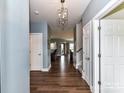 Bright hallway with hardwood floors leads into a seamlessly connected living and dining space at 3012 Ocean Dr, Monroe, NC 28110