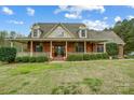 Lovely brick home with a covered porch, featuring manicured landscaping and a well-maintained lawn at 361 Nance Rd, Stanfield, NC 28163