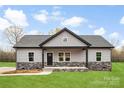 Inviting single-story home with gray siding, stone accents, and a covered front porch at 3957 Miller Rd, Salisbury, NC 28147