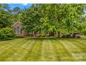 Beautiful brick home boasting a meticulously maintained lawn and mature trees at 4159 Isle Of Pines Dr, Denver, NC 28037