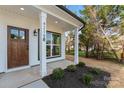Close-up of a charming front porch with a wood door and manicured landscaping at 4219 Brownwood Nw Ln, Concord, NC 28027