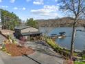 Stunning lakefront home with a private driveway, lush landscaping, and a charming covered porch overlooking the water at 466 Shoreline Rd, New London, NC 28127