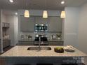 Stylish kitchen with gray cabinetry, stainless steel appliances, and a granite island with sink at 4724 Lakeview Rd # 26, Charlotte, NC 28216