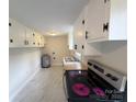 Galley kitchen with updated appliances, white cabinets, and wood countertops at 512 Hall St, Salisbury, NC 28144