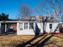 The backyard has a covered carport and chain link fence on a sunny day with a blue sky at 58 Kentucky Sw Ave, Concord, NC 28027