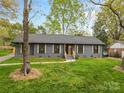 Single-story home with a neatly kept lawn, classic shutters, and a paved walkway leading to the entrance at 7009 Wrentree Dr, Charlotte, NC 28210