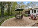 Paved patio area with outdoor seating surrounded by mature trees and landscaping at 7710 Epping Forest Dr, Huntersville, NC 28078