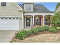 Close-up of home entrance featuring a white door, brick columns and manicured landscaping at 8812 Heron Glen Dr, Charlotte, NC 28269