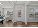 Inviting entryway with wood floors, a decorative front door, and a view into the bright living space at 9582 Creighton Nw Rd, Concord, NC 28027