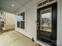 Elegant front entrance featuring a decorative glass door, covered porch, and stylish exterior finishes at 9582 Creighton Nw Rd, Concord, NC 28027
