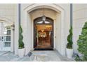 Grand entrance with stone tile, manicured spiral topiary and a glimpse of the interior at 11236 Mcclure Manor Dr, Charlotte, NC 28277