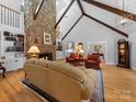 Inviting living room with a soaring stone fireplace, built-in bookshelves, and hardwood floors at 1206 Heatherloch Dr, Gastonia, NC 28054