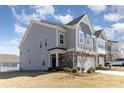 A gray two-story townhome features manicured landscaping and an attached two-car garage at 1243 Pebble Grove Dr # 442, Clover, SC 29710