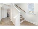 A staircase is shown with white risers and wood treads with a large window at 1243 Pebble Grove Dr # 442, Clover, SC 29710
