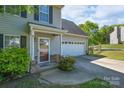 Home featuring a covered porch, driveway, an attached garage, and beautifully landscaped front yard at 12604 Cardinal Point Rd, Charlotte, NC 28269