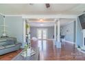 Open living area with hardwood floors, white columns, and access to an outdoor patio at 12842 Plaza Road Ext, Charlotte, NC 28215