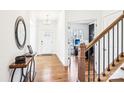 Inviting foyer featuring hardwood floors, a decorative mirror, and a glimpse into the home office at 13102 Petrel Pl, Charlotte, NC 28278