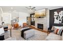 Stylish living room with a brick fireplace, modern decor, and hardwood floors at 13102 Petrel Pl, Charlotte, NC 28278