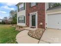 Beautiful walkway and entry to the house, with stone features, flower beds, and green front door at 140 Camforth Dr, Mooresville, NC 28117