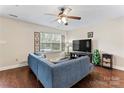 Cozy living room with a large window, comfortable seating, a ceiling fan, and wood-look flooring at 140 Camforth Dr, Mooresville, NC 28117