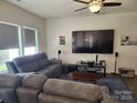 Relaxing living room with comfortable gray couches, television, and a ceiling fan at 14022 Clayborn St, Midland, NC 28107