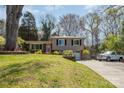 Split-level home with a brick and siding exterior, front lawn and long driveway at 1421 Sherwood Dr, Kannapolis, NC 28081