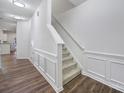 Bright hallway with stairs, wainscoting, and modern lighting at 14256 Drake Watch Ln, Charlotte, NC 28262