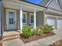 Inviting front porch featuring brick steps, white pillars, and cozy seating with blue chairs at 152 Amerson Dr, Rock Hill, SC 29730