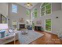 Bright living room with soaring ceilings, large windows, fireplace, and hardwood floors at 17301 Glassfield Dr, Huntersville, NC 28078