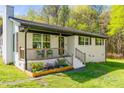 Charming exterior showcasing a cozy porch, flower bed, manicured lawn, and white brick at 1849 Harris Rd, Fort Mill, SC 29708