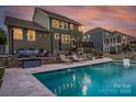 Expansive backyard featuring a luxurious pool, outdoor seating area, and a well-maintained lawn at 2220 Gallberry Ln, Waxhaw, NC 28173