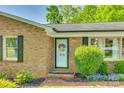 Inviting front entrance with brick details, a decorated door, and lush greenery at 236 Greendale Dr, Mount Holly, NC 28120