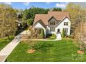 Aerial view of an elegant home with lush landscaping and a curved driveway on a sunny day at 318 Montrose Dr, Waxhaw, NC 28173