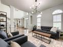 Spacious living room featuring high ceilings, arched windows, and open access to the foyer and front door at 6114 Abergele Ln, Matthews, NC 28104