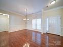 Bright dining room with hardwood floors, elegant chandelier, large windows, and beautiful trim at 7524 Common Oak Dr, Stanley, NC 28164